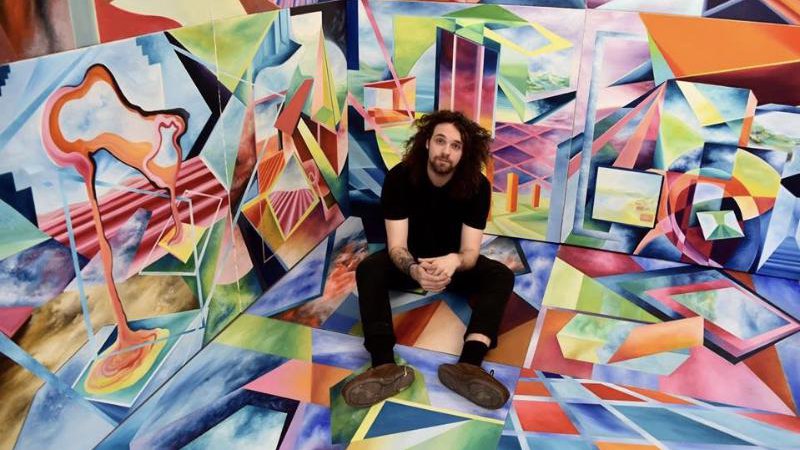 Brennan sitting inside the painted Organic and Mechanical Space installation