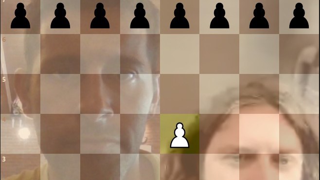 Online chess game with both players' webcams showing through the board